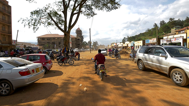 A bustling street scene, with several people on motorcycles.