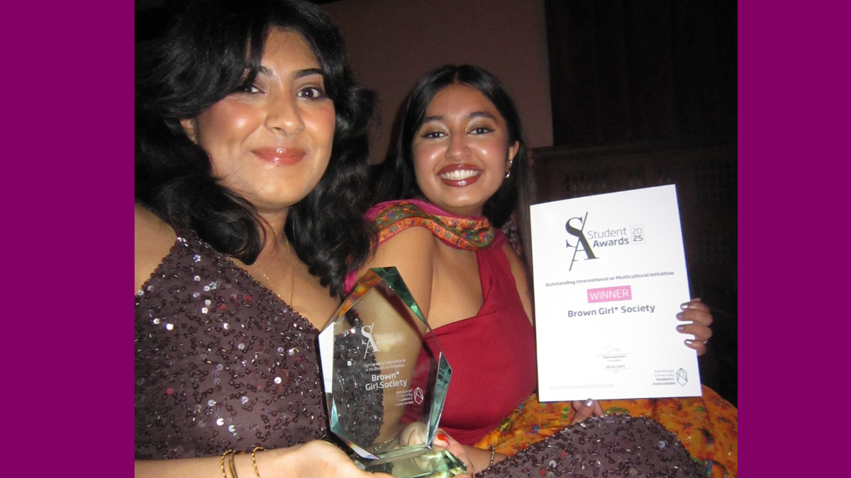 Photo of co-presidents Wardah and Kaashvi at the Student Awards. Wardah is holding an award made of glass and Kaashvi is holding a certificate that reads 'Student Awards: Winner: Brown Girl Society'. They are both smiling and wearing beautiful, ball-like dresses.