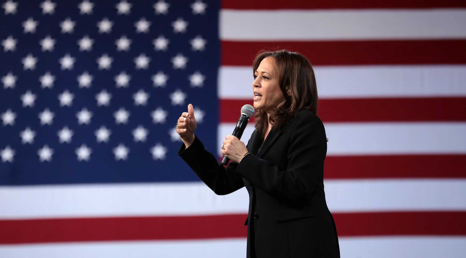 Image of Kamala Harris speaking, with an American flag background.