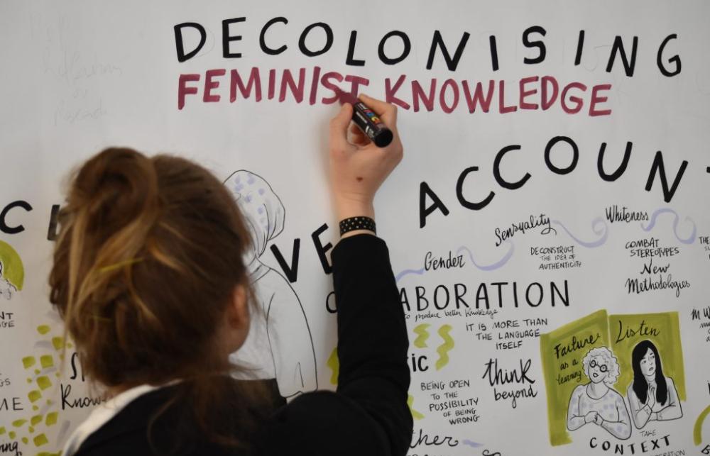 Words written on a whiteboard: Decolonising Feminist Knowledge