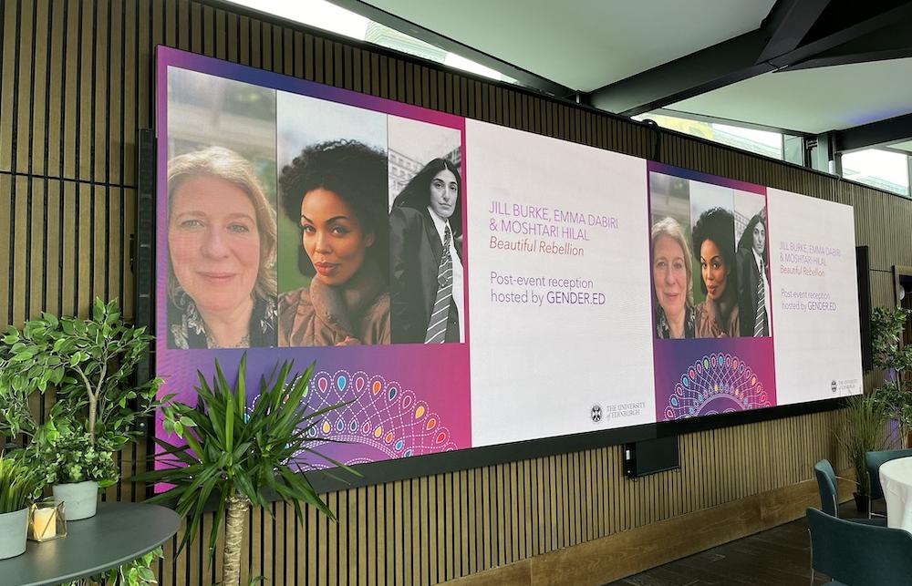 a screen with photographs of the three authors